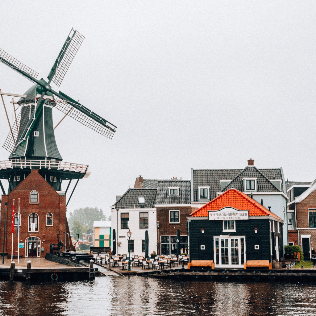 Мельница и дома на берегу реки 