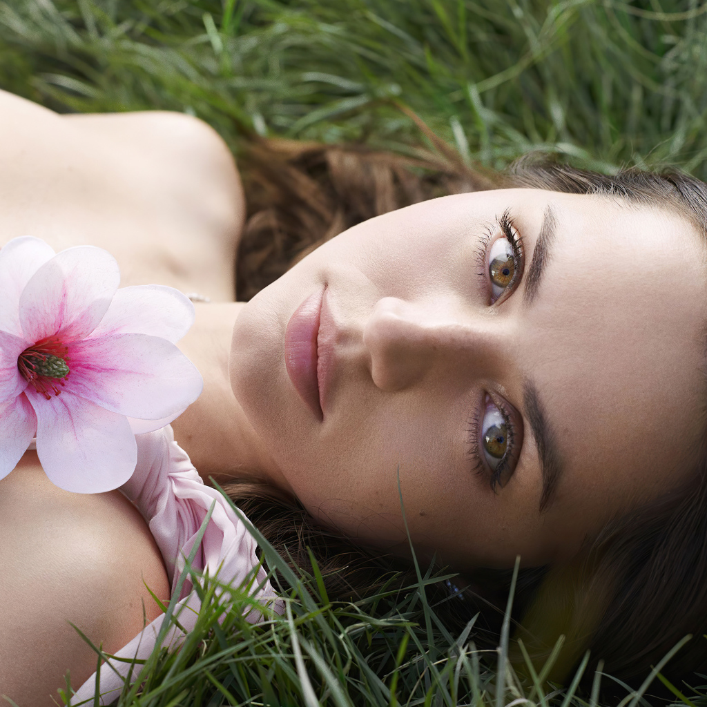 Актриса Ана де Армас лежит на зеленой траве с цветком