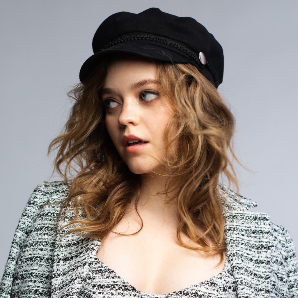 Актриса Джэйд Петтиджон смотрит в сторону на сером фоне