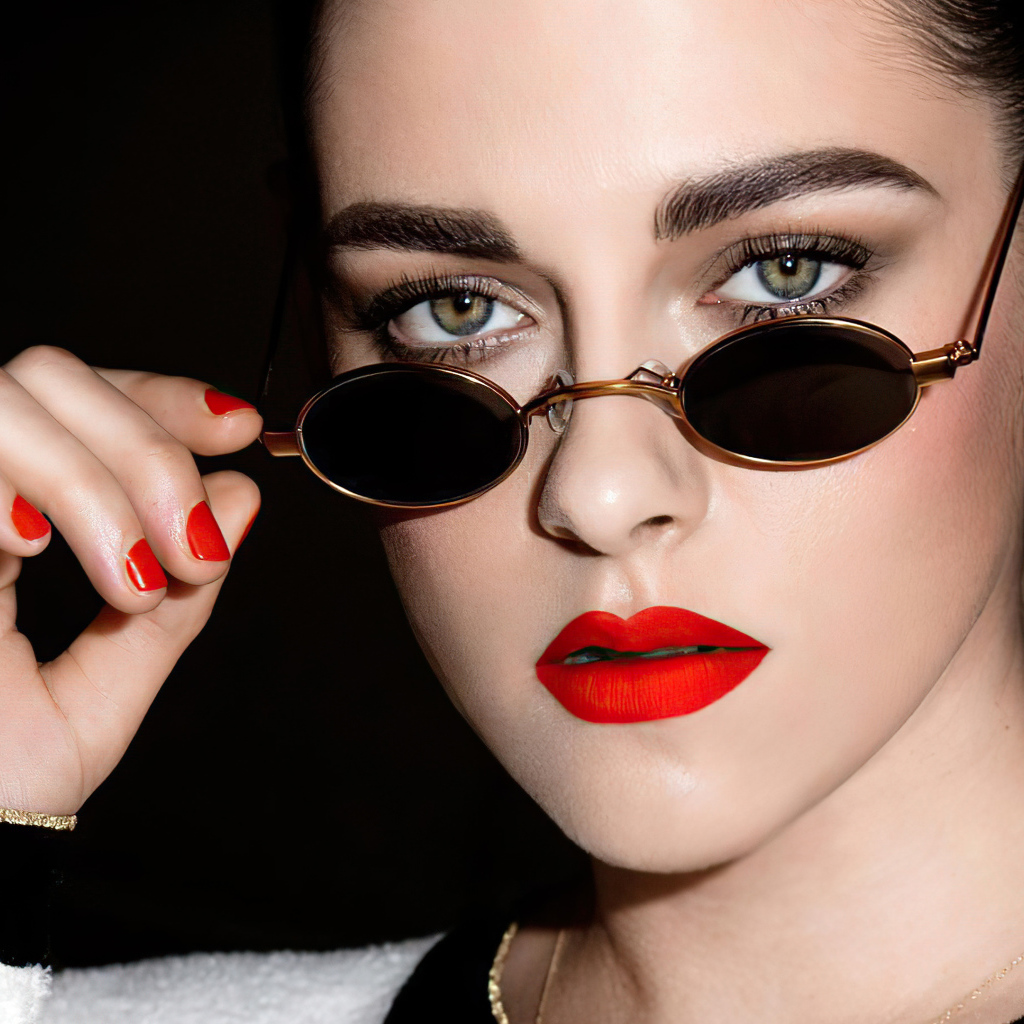 Актриса Кристен Стюарт в очках на  черном фоне