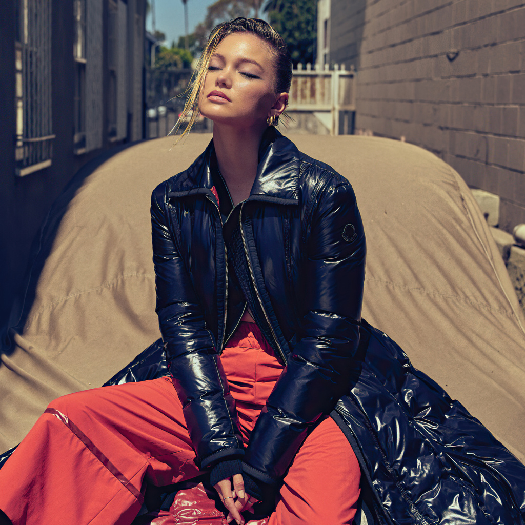 Актриса Оливия Холт в черной куртке сидит на машине