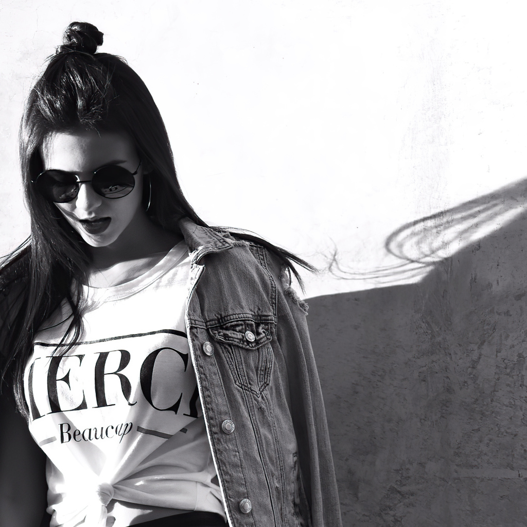 Актриса  Виктория Джастис в очках у стены