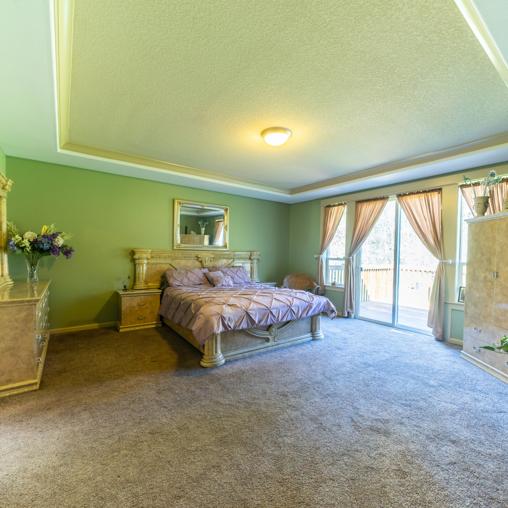 Красивая большая спальня с зелеными стенами 