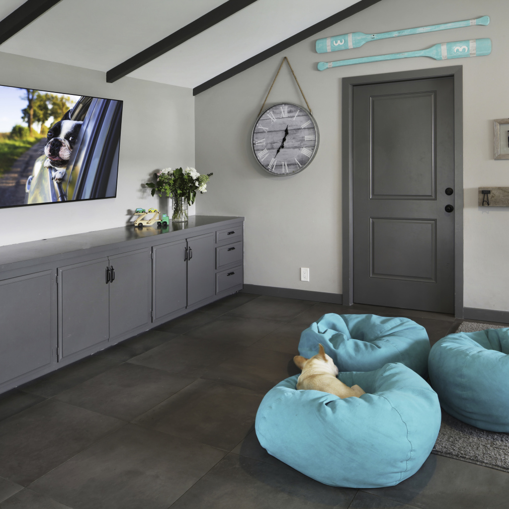 Голубые кресла в комнате с большим телевизором 