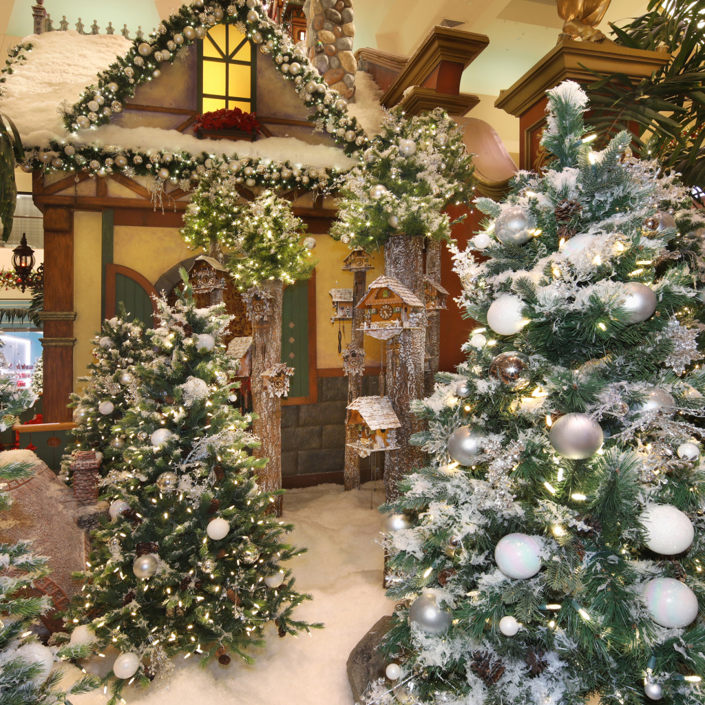 Новогодние ели стоят в комнате с декором 