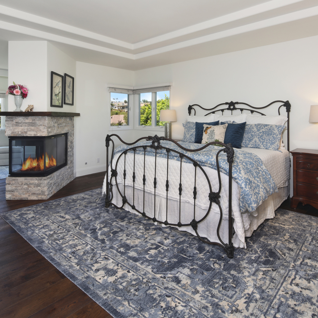 Уютная спальная комната с камином и большой кроватью