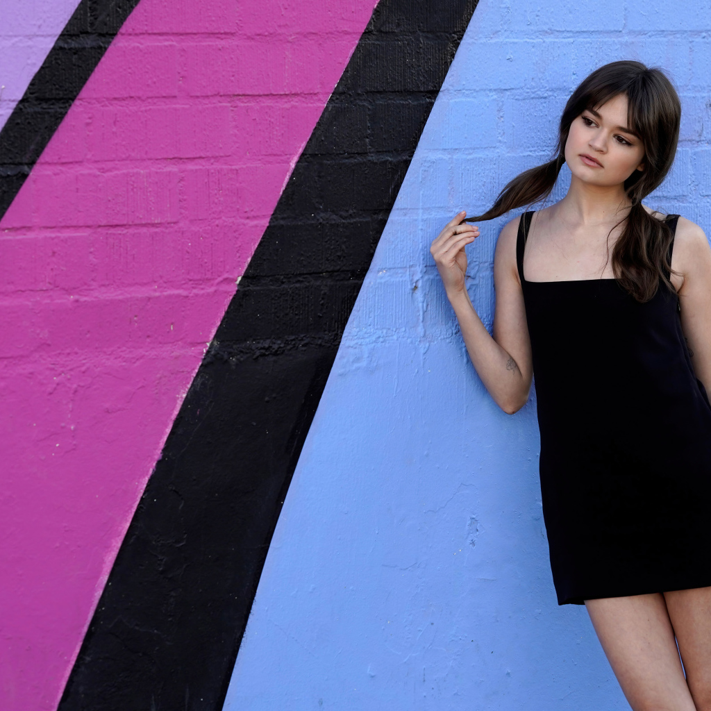 Милая девушка актриса Сиэра Браво у разноцветной стены