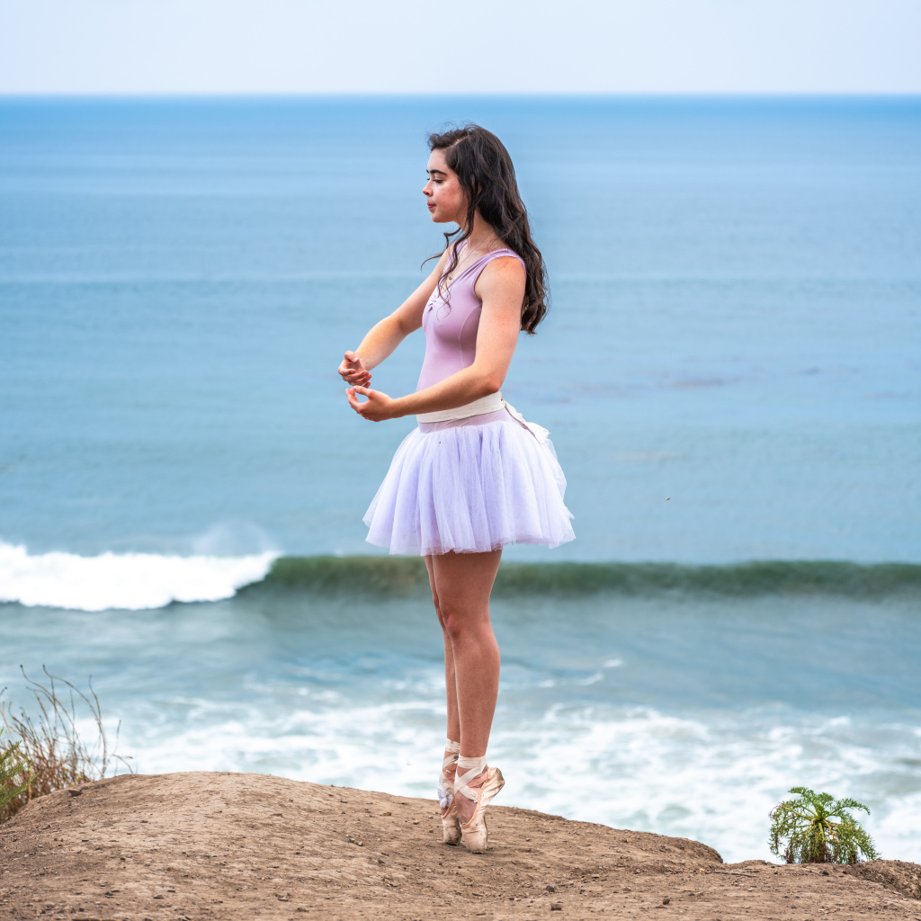 Девушка балерина занимается на берегу океана