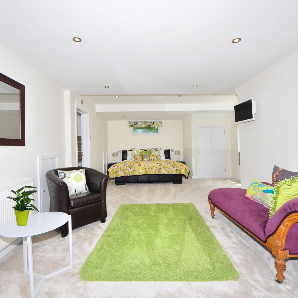 Большая гостиная с высокими белыми стенами и мебелью 