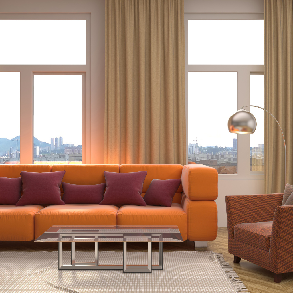 Большой оранжевый диван с подушками у окна 
