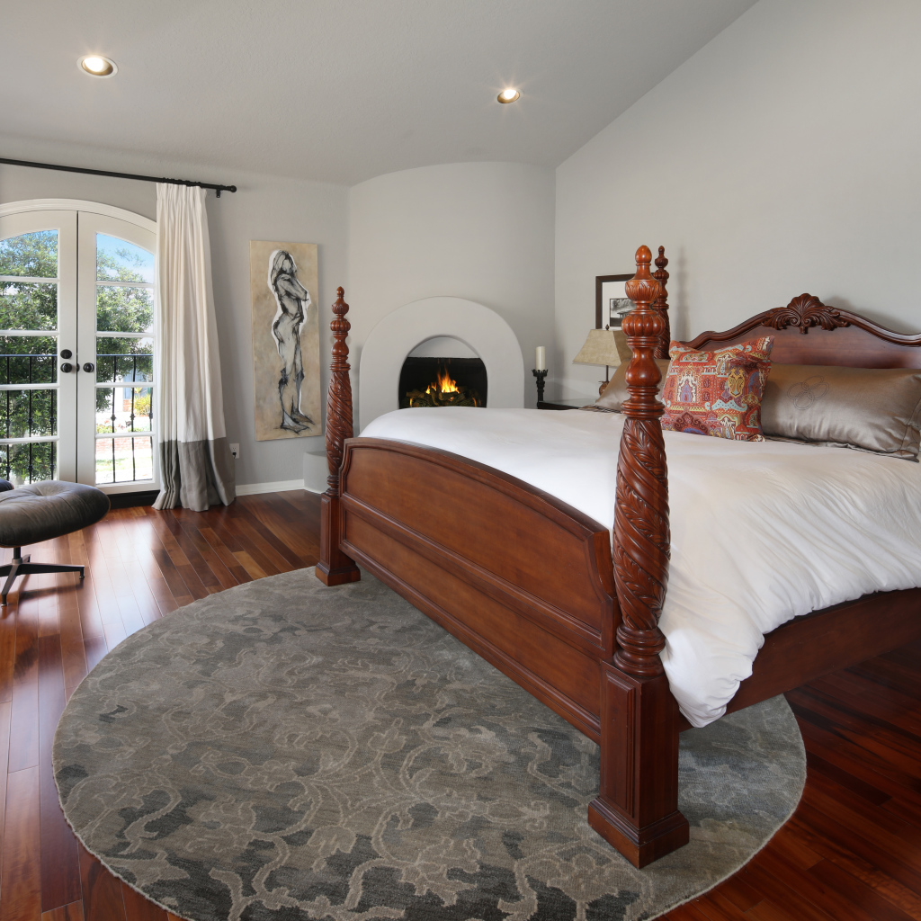 Large wooden bed in the bedroom with fireplace