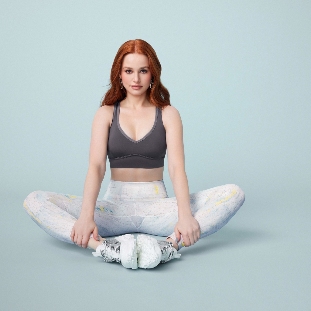 Рыжеволосая американская актриса Мэделин Петш сидит в позе лотоса