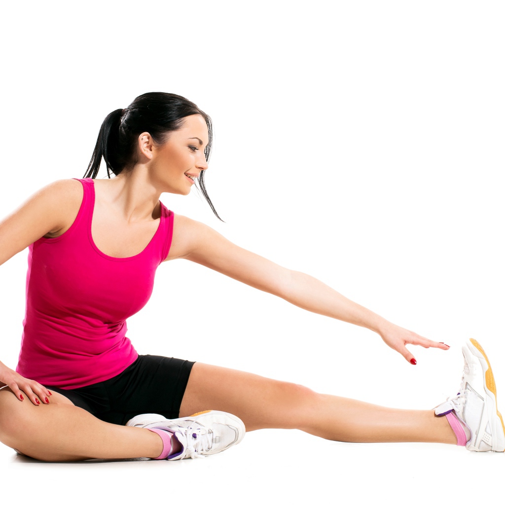 Спортивная девушка делает растяжку на белом фоне 