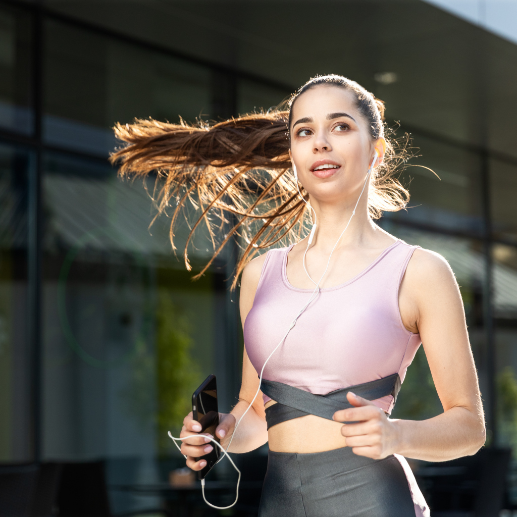 Спортивная девушка занимается бегом на улице