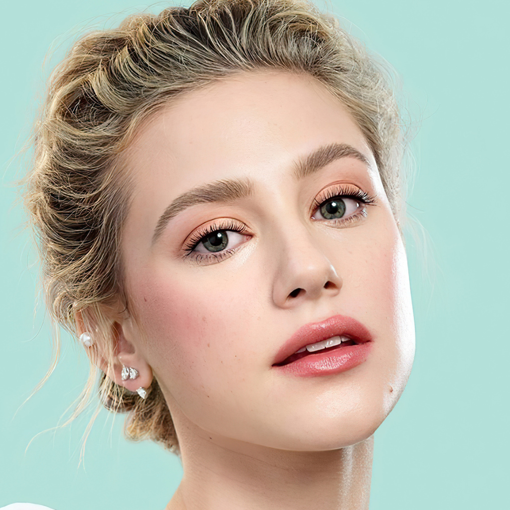 Лицо актрисы Лили Рейнхарт на голубом фоне