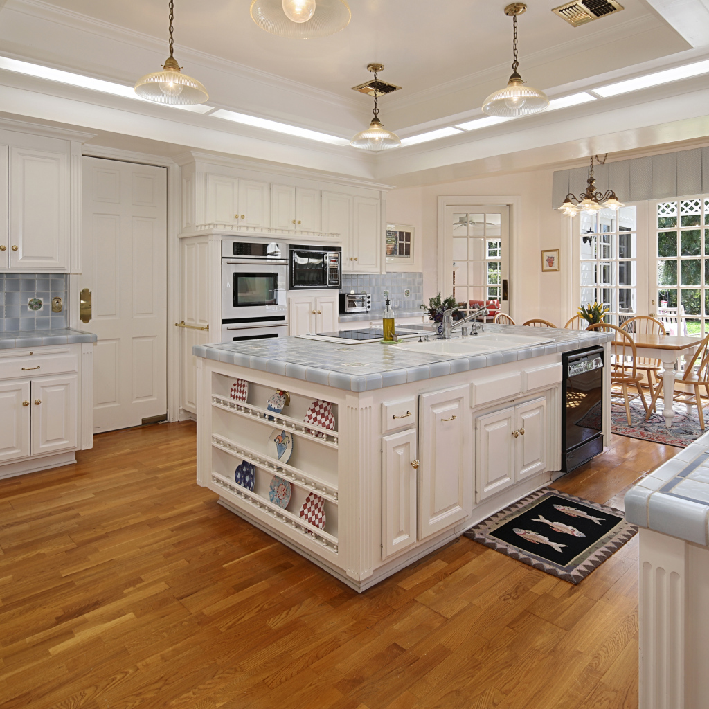 Белые стены и мебель на просторной современной кухне 