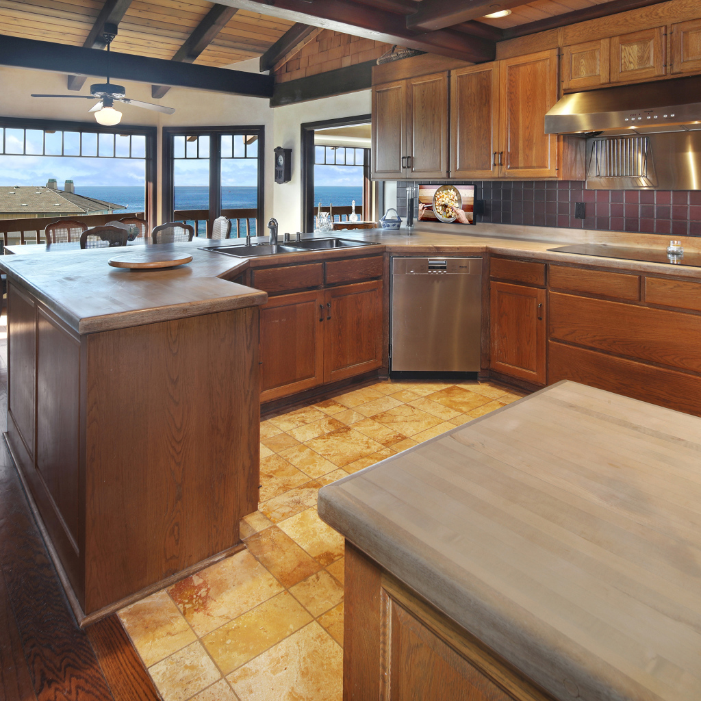 Деревянная мебель на кухне с окнами с видом на море