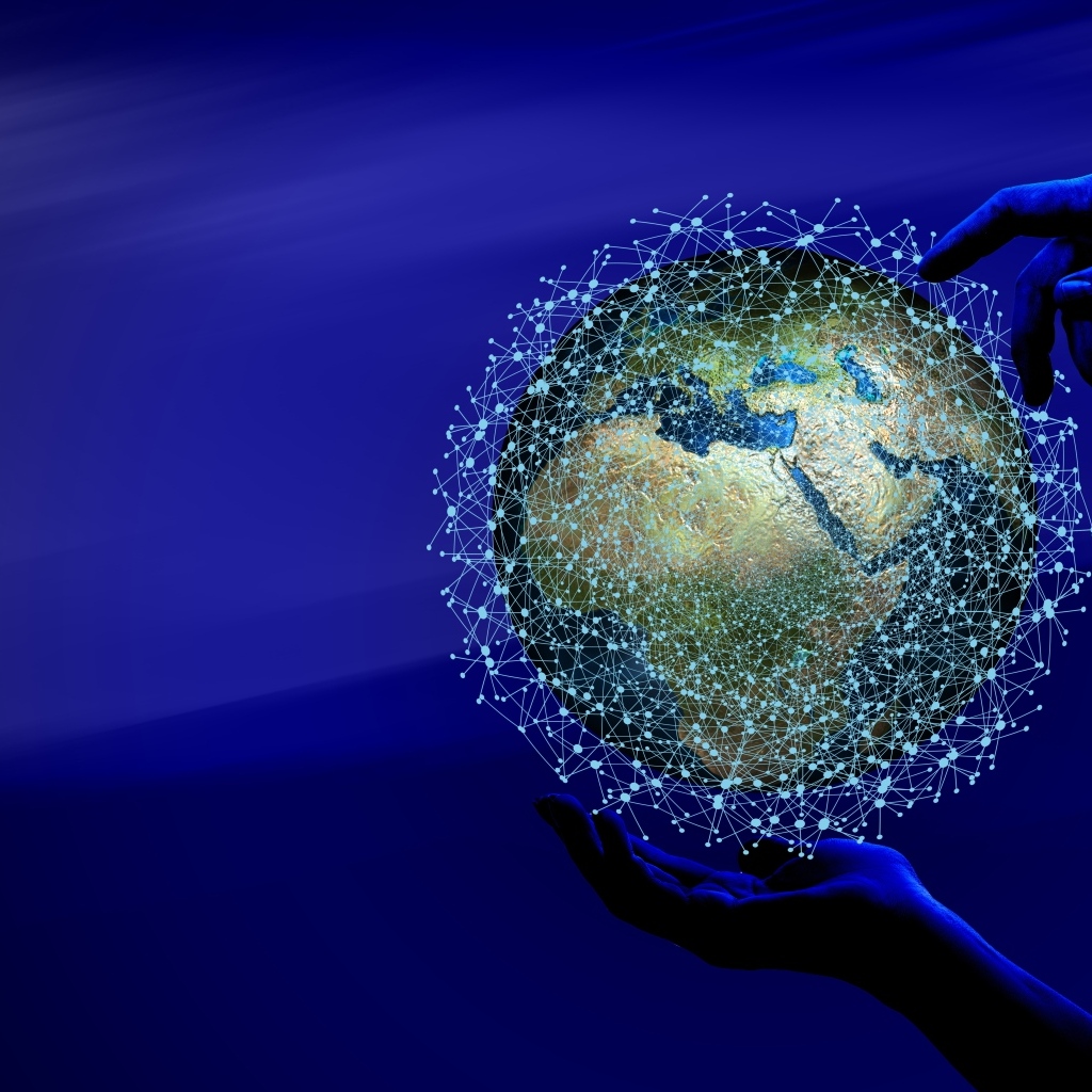 Земля в информационной паутине в руках на синем фоне