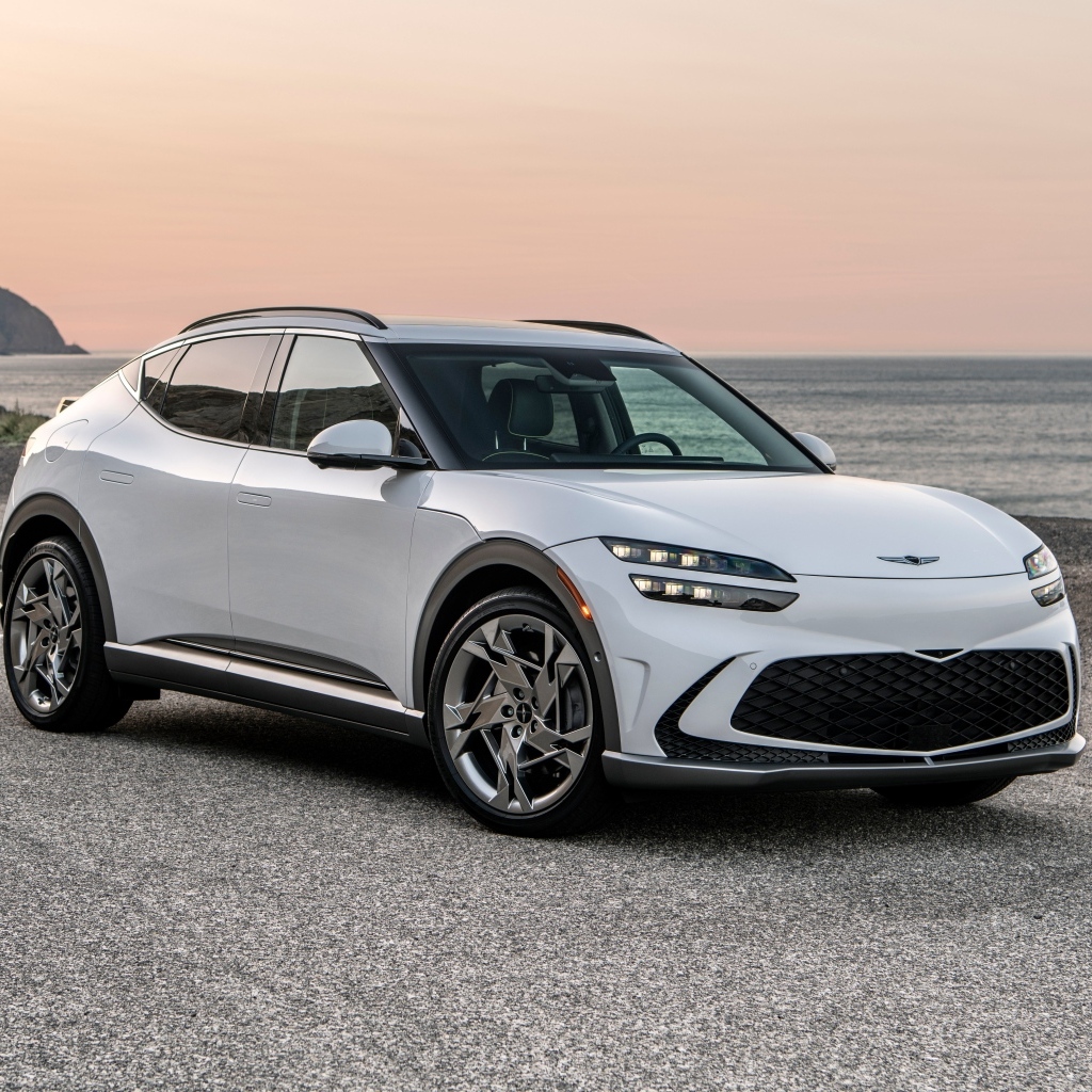 Белый автомобиль Genesis GV60, 2023 года на пляже