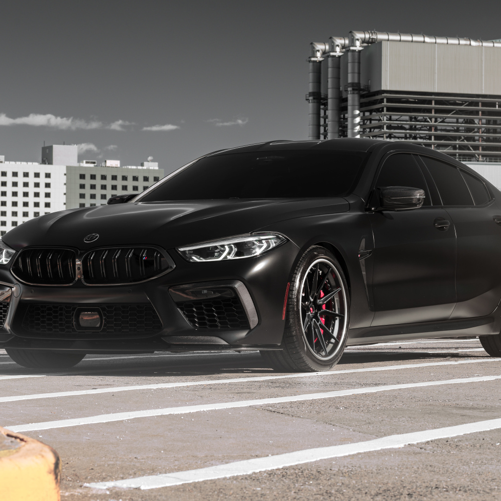 Черный автомобиль BMW M8 на стройке
