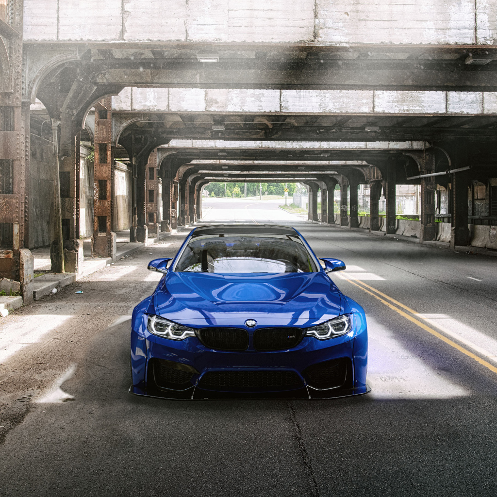 Синий автомобиль BMW M4 под мостом