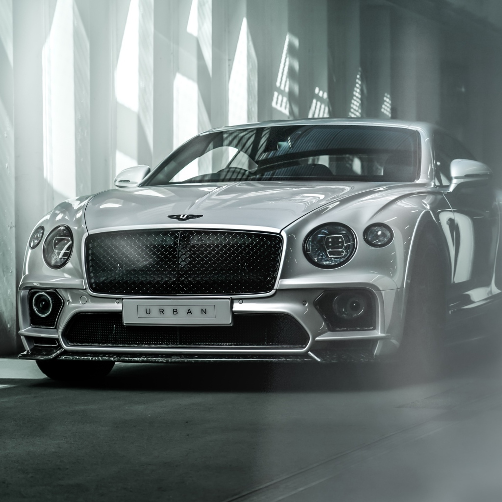 Серебристый автомобиль Bentley Continental GT в здании
