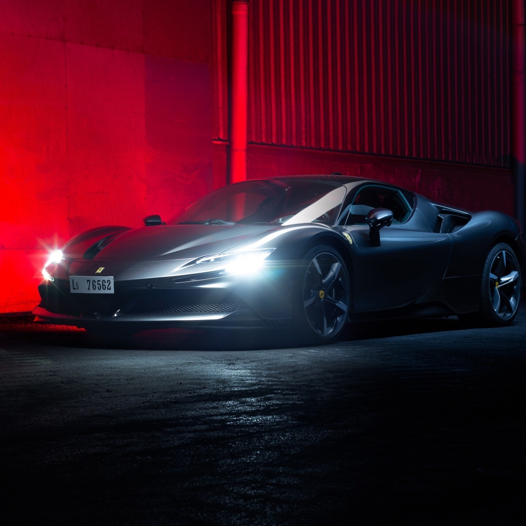 Автомобиль Ferrari SF90 Stradale с включенными фарами на красном фоне