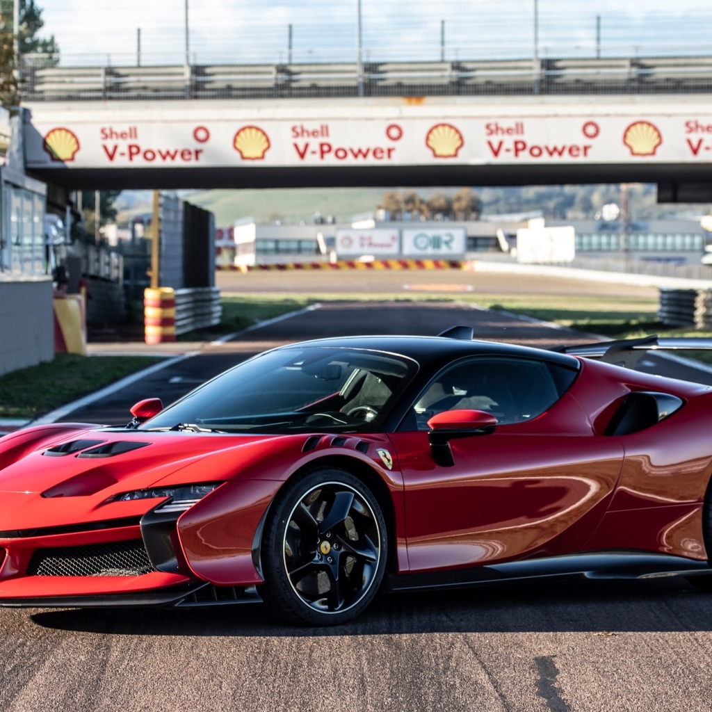 Красный автомобиль Ferrari SF90 XX Stradale на стадионе