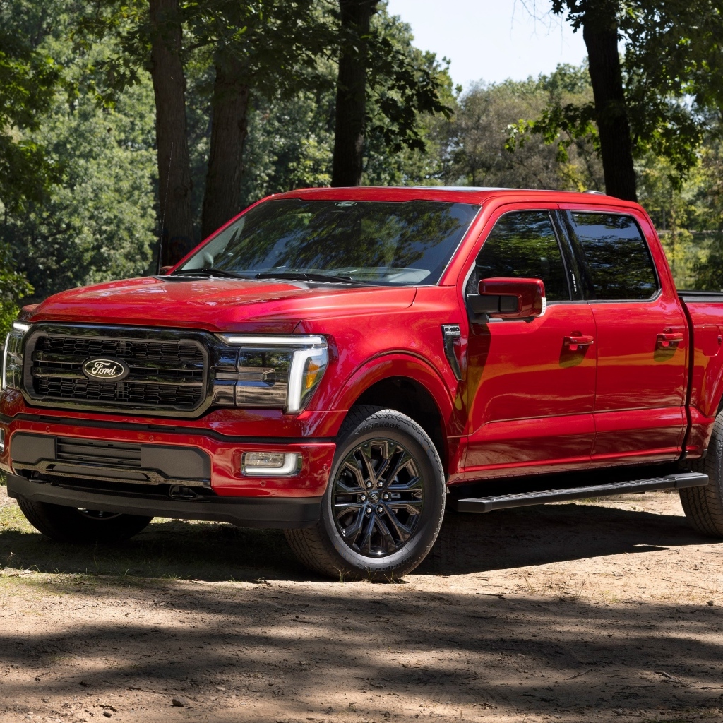 Большой красный Ford F-150 Lariat 2024 года в лесу