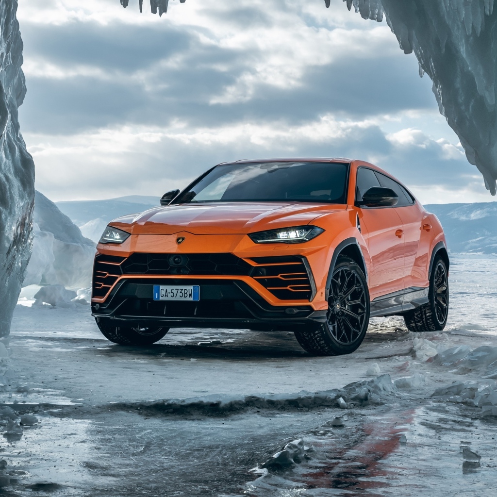 Оранжевый внедорожник Lamborghini Urus у ледяной пещеры