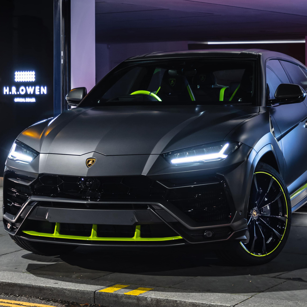 Серебристый Lamborghini Urus с включенными фарами