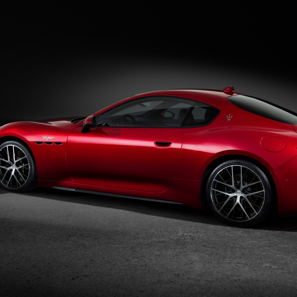 Красный автомобиль Maserati GranTurismo Trofeo 2023 на сером фоне