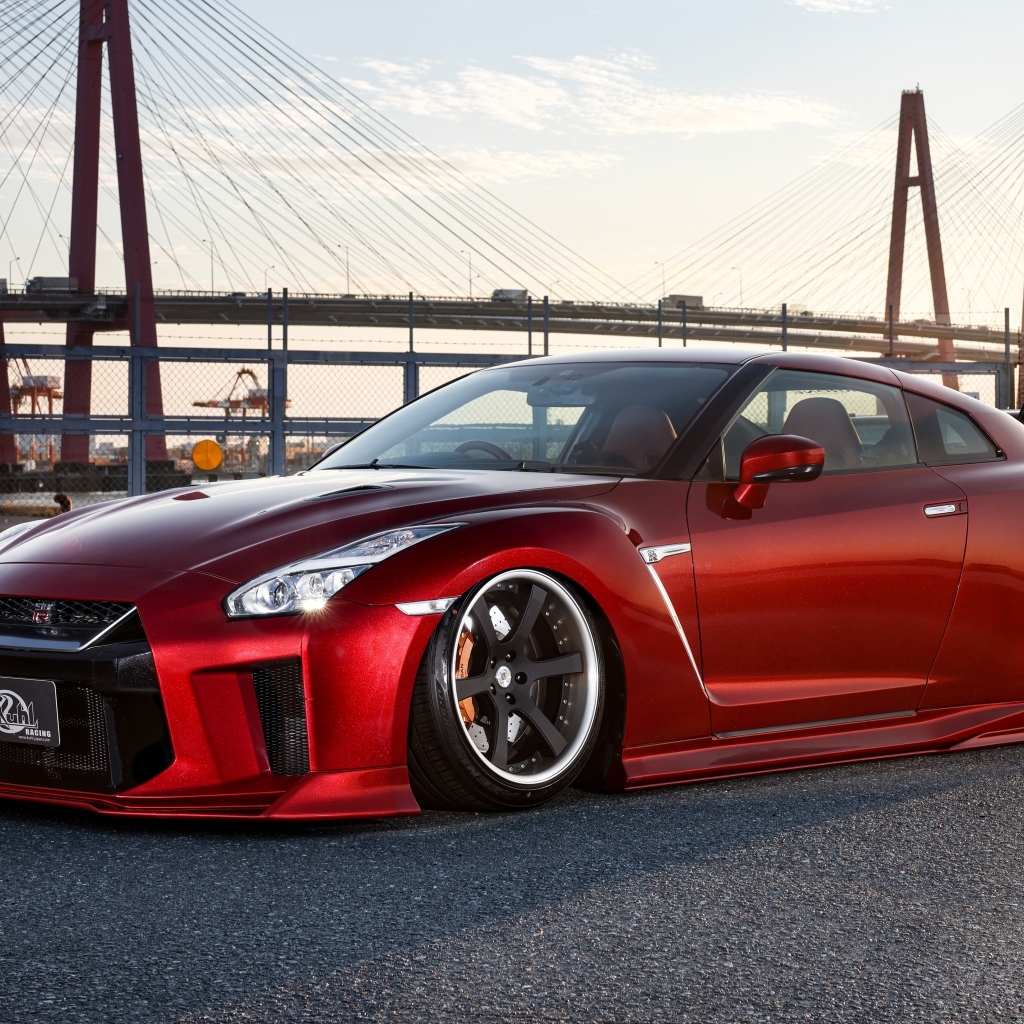 Красный автомобиль Nissan GTR 35R на фоне моста
