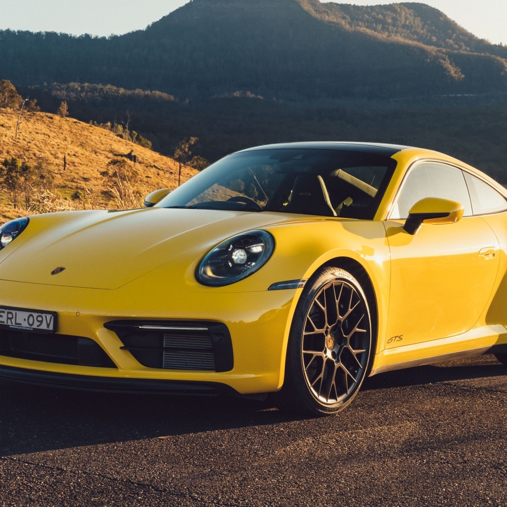 Желтый быстрый автомобиль Porsche 911 Carrera GTS вид спереди
