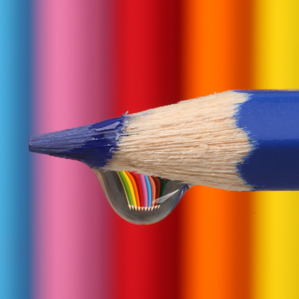 Капля воды стекает с синего карандаша