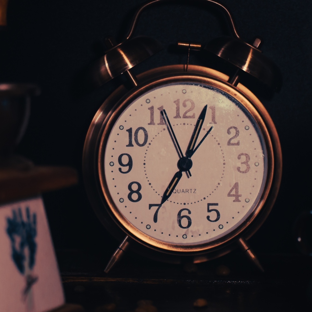 Большой будильник показывает семь часов