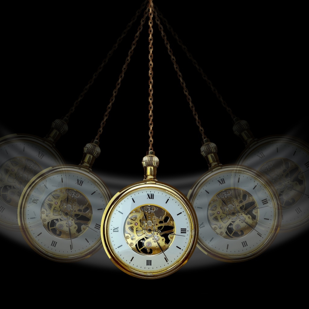 Карманные часы раскачиваются на черном фоне