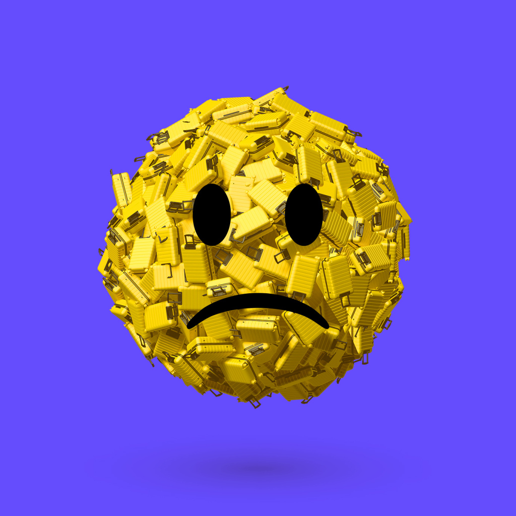 Грустный смайлик из чемоданов на синем фоне