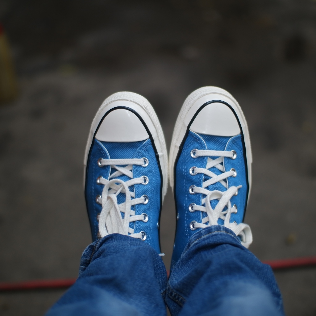 Кеды на ногах в джинсах