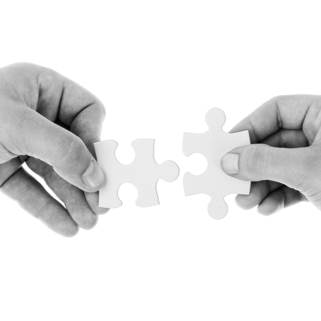Два белых пазла в руках 