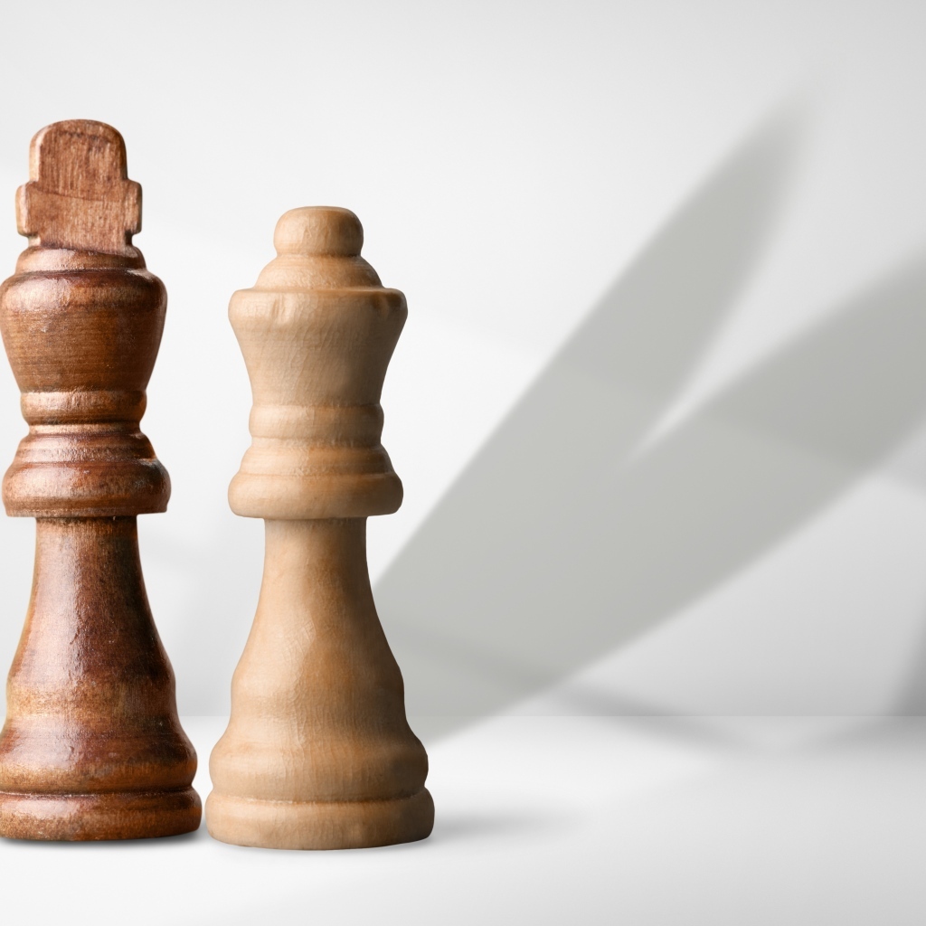 Две деревянные шахматные фигуры на сером фоне