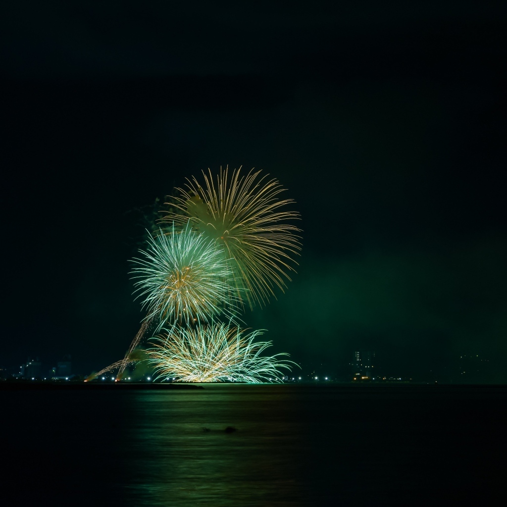 Вид с воды на красивые искры салюта