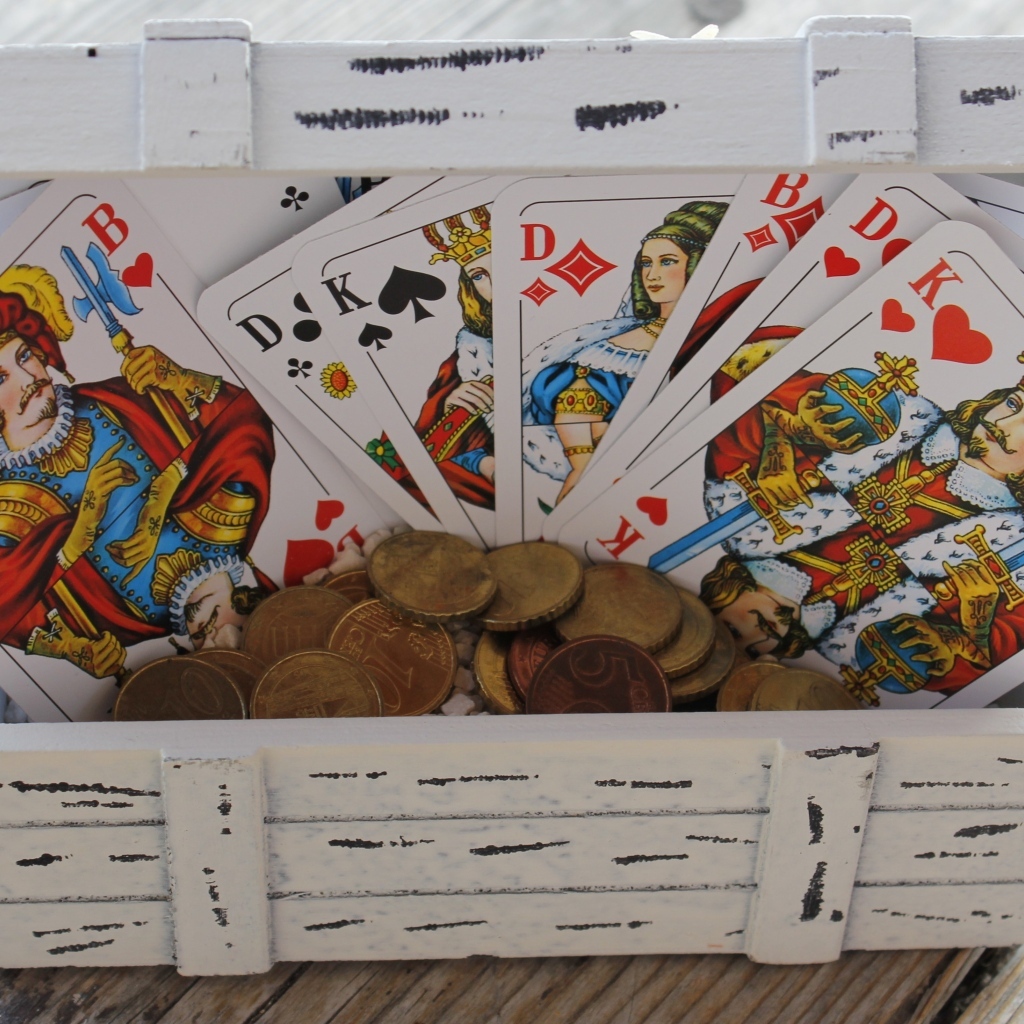 Колода карт и монеты в деревянной шкатулке