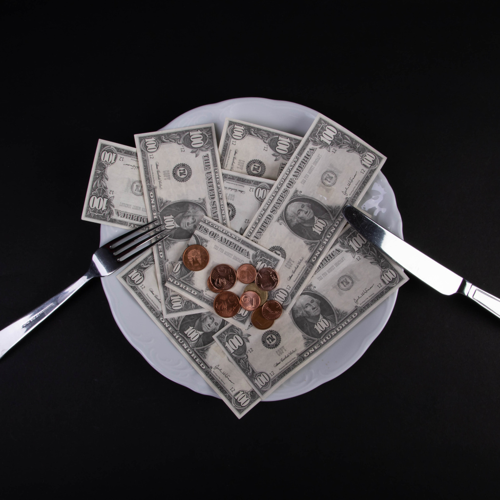 Тарелка с долларами на черном фоне