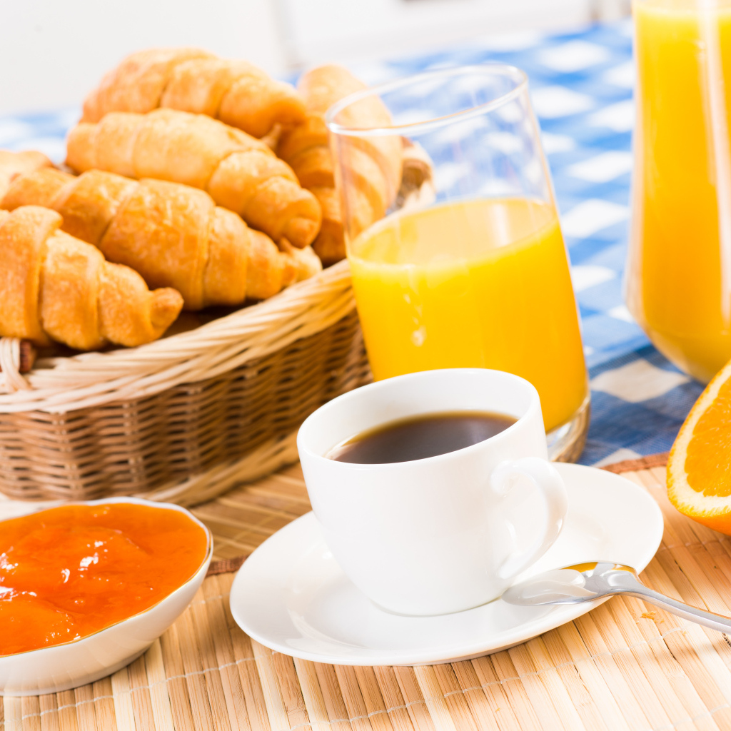 Кофе с круассанами и соком на столе на завтрак
