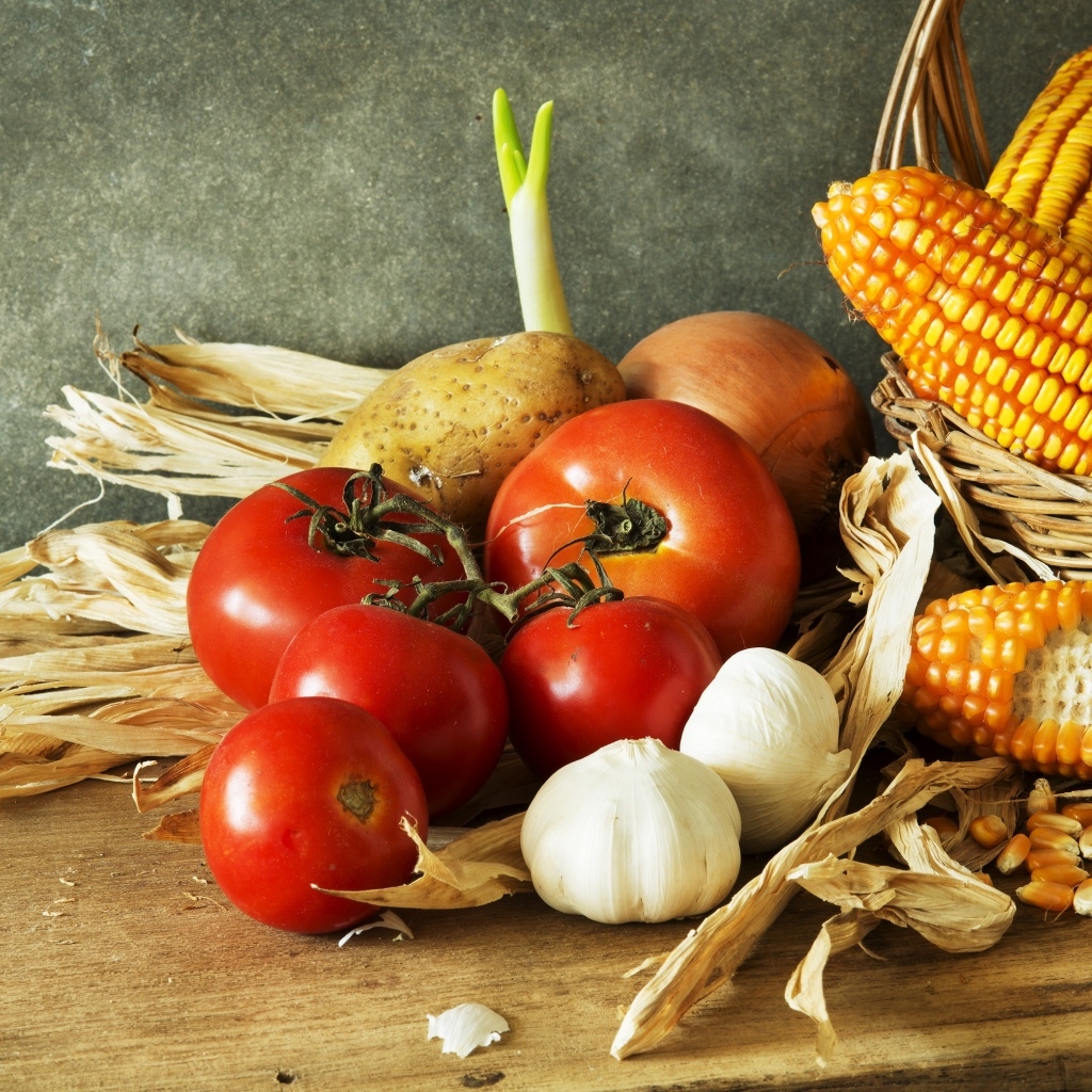 Кукуруза, чеснок и помидоры на столе