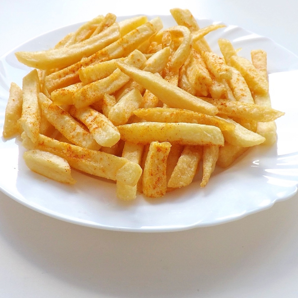 Картофель фри на большой белой тарелке