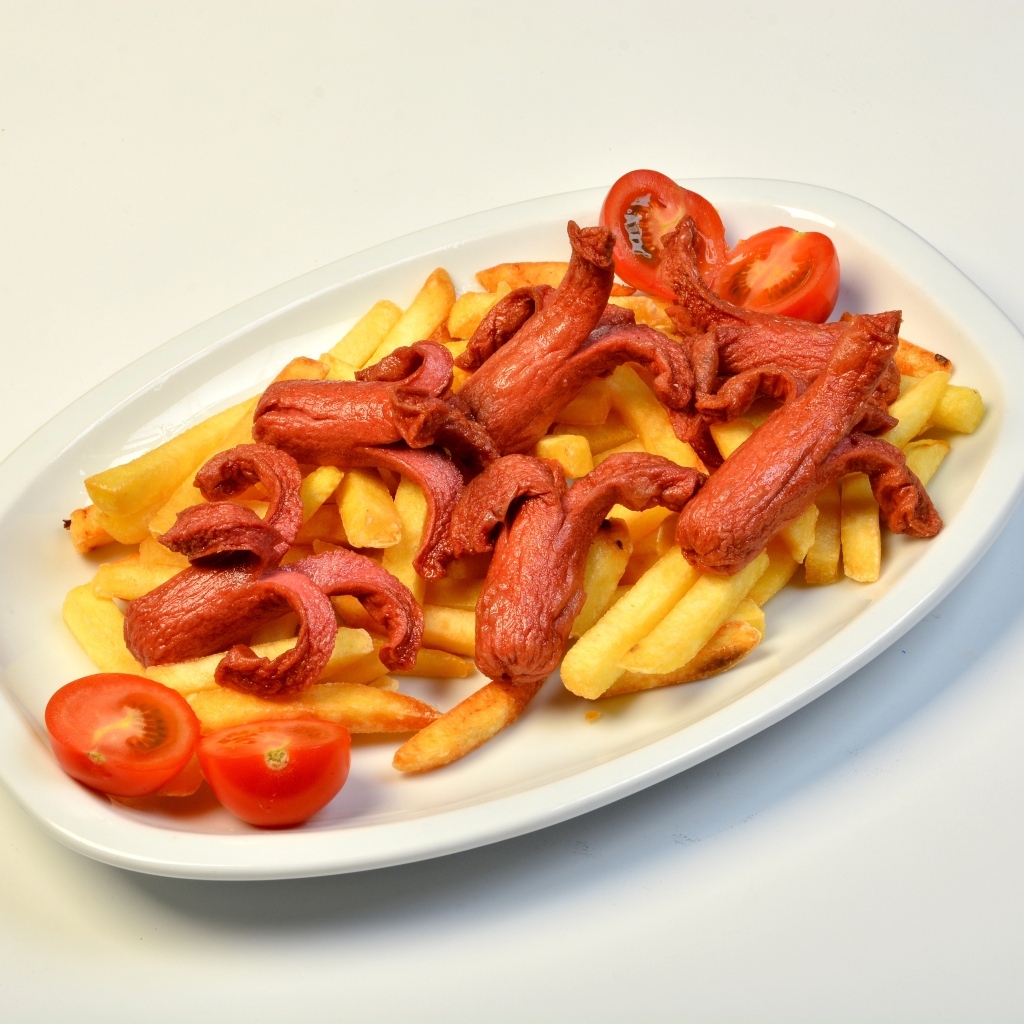 Картофель фри на тарелке с помидорами и сосисками
