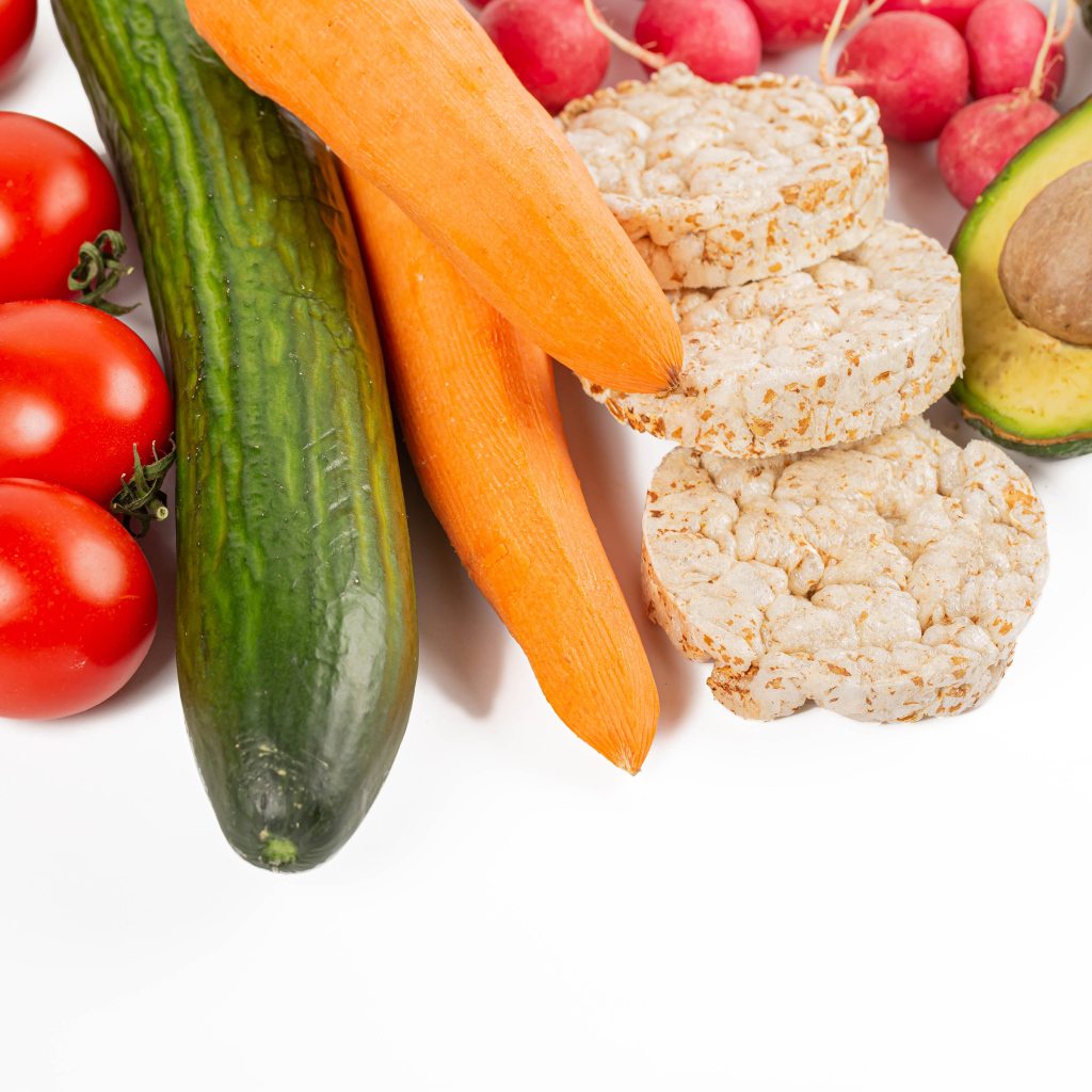 Свежие аппетитные овощи и хлопья на белом фоне