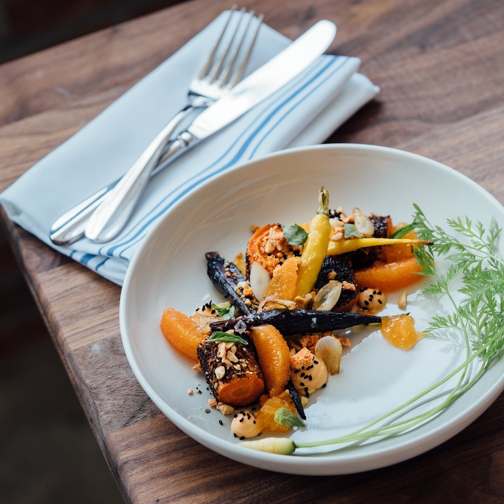 Жареные овощи на тарелке со столовыми приборами